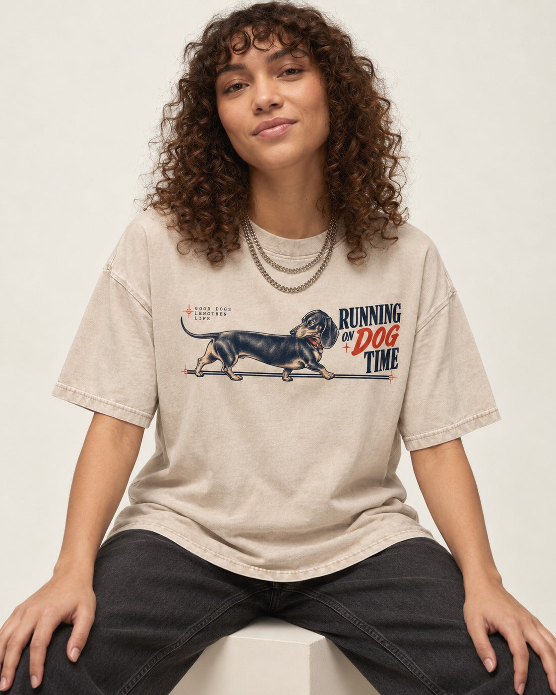 Dachshund Lengthens Life Washed Tee in Apricot, worn by a seated model
