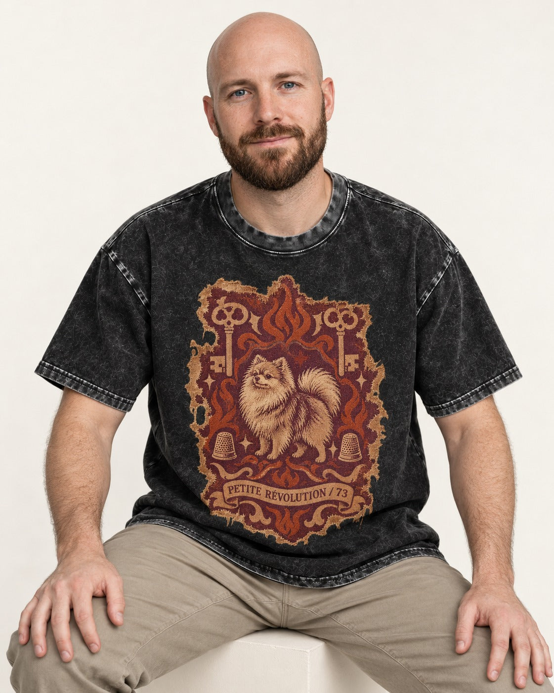 Pomeranian Petite Revolution Ornate Key Emblem Graphic Washed Tee in Black, worn by a seated model