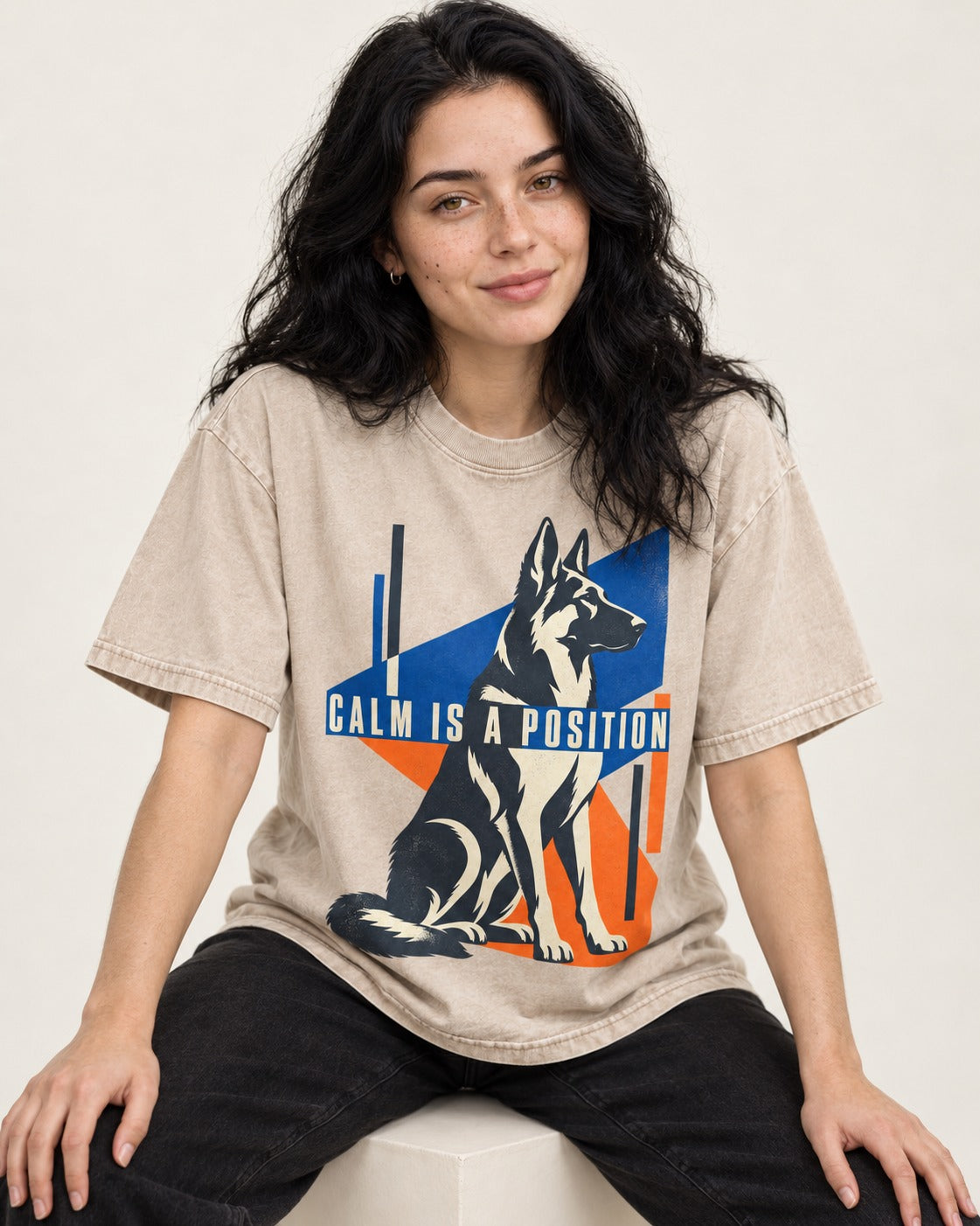 Calm Is A Position Geometric German Shepherd Dog Graphic Washed Tee in Apricot, worn by a seated model
