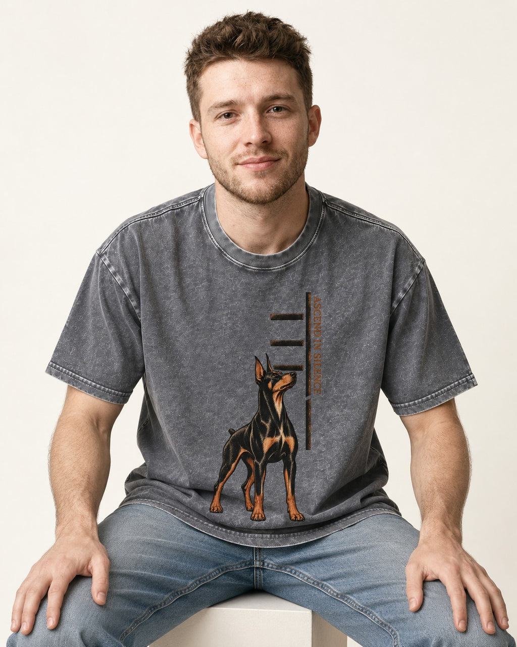 Doberman Ascend in Silence Washed Tee in Gray, worn by a seated model
