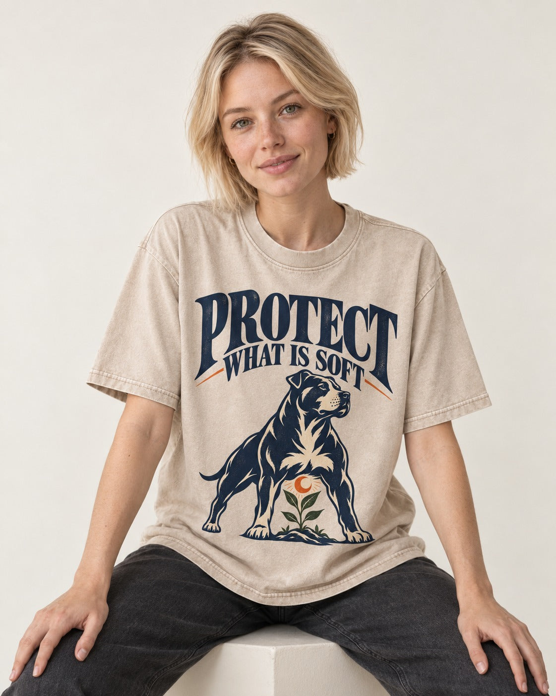 Protect What Is Soft Pitbull Washed Tee in Apricot, worn by a seated model