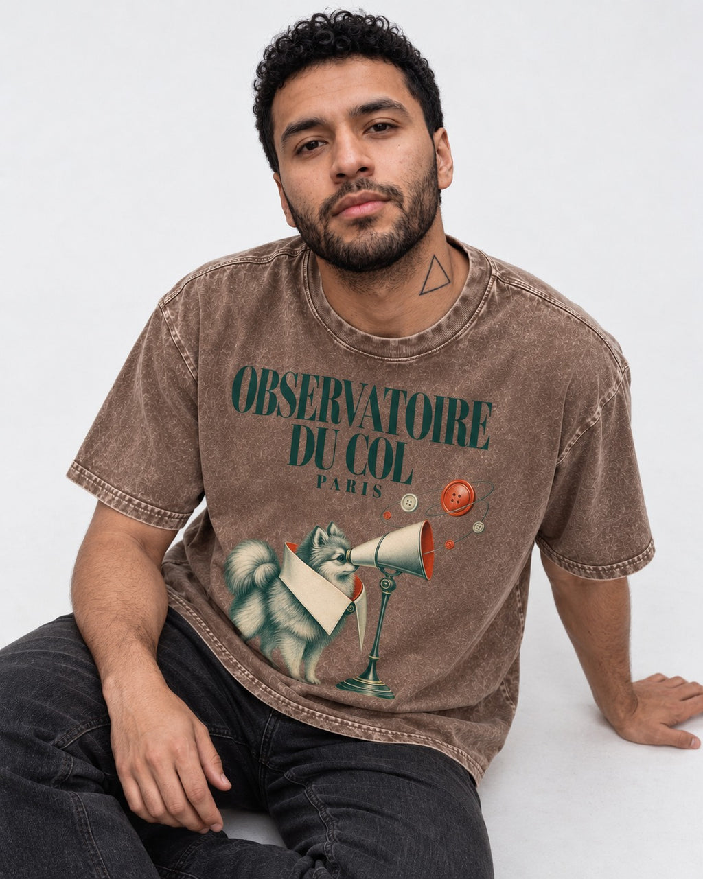 Pomeranian Observatoire Du Col Washed Tee in Coffee, worn by a seated model