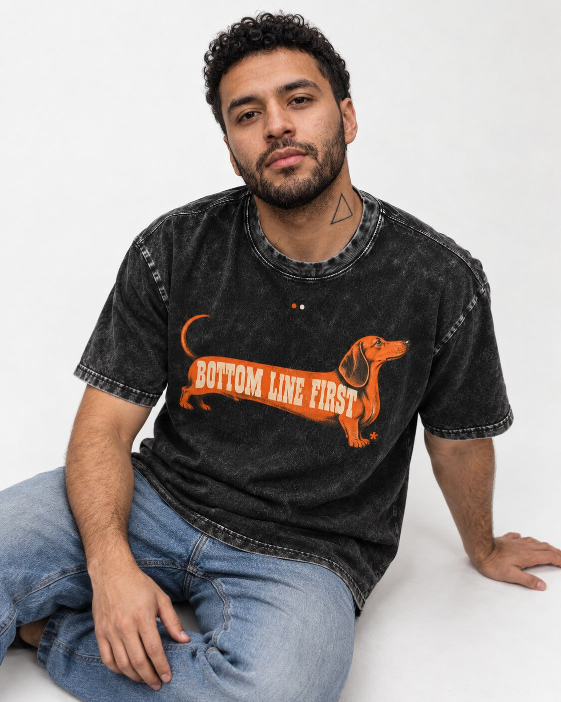Dachshund Bottom Line First Body Lettering Graphic Washed Tee in Black, worn by a seated model