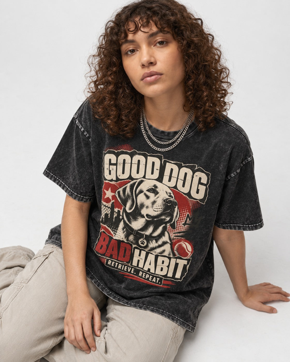 Labrador Retriever Good Dog Bad Habit Poster Graphic Washed Tee in Black, worn by a seated model
