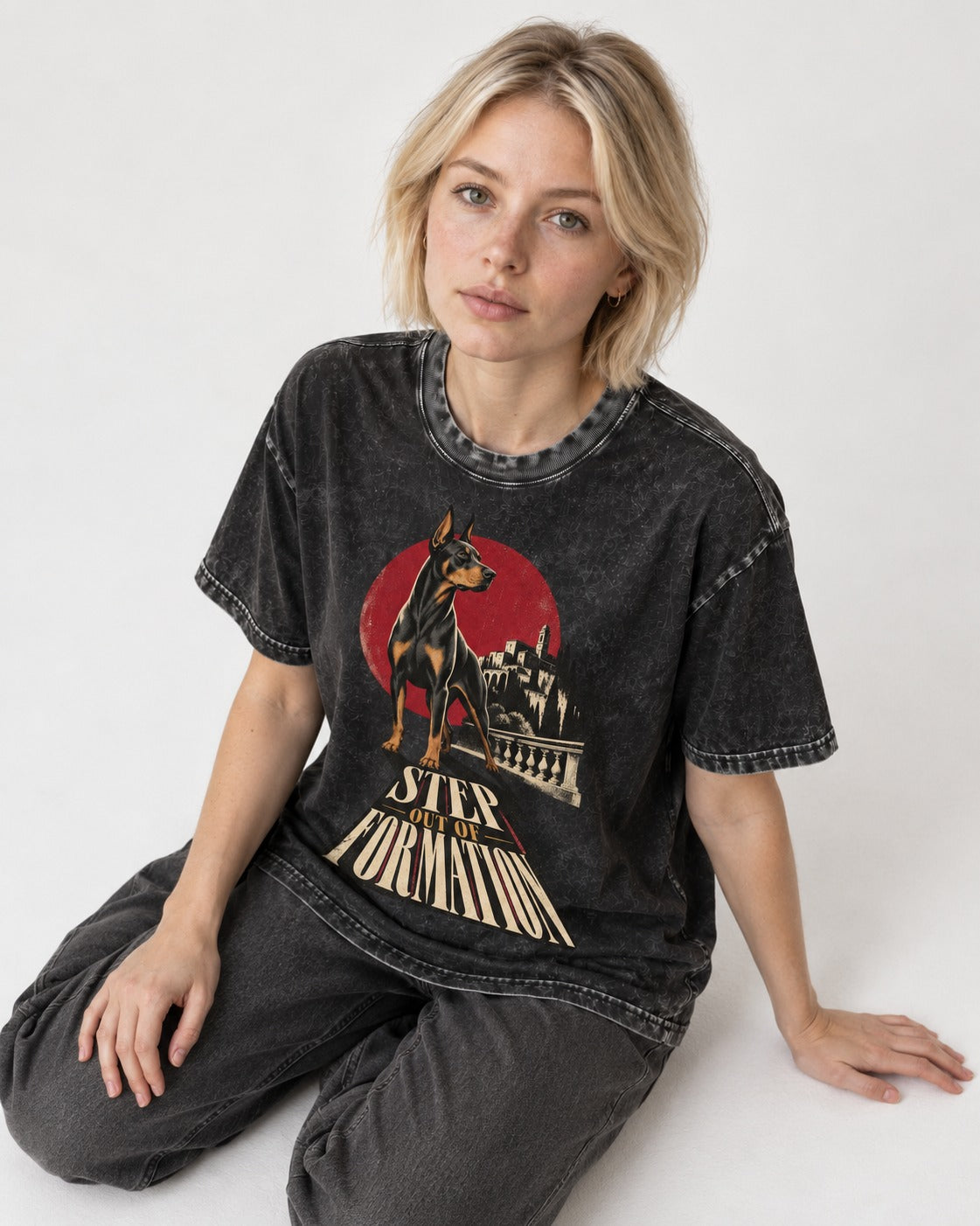 Doberman Step Out of Formation Road Vista Graphic Washed Tee in Black, worn by a seated model