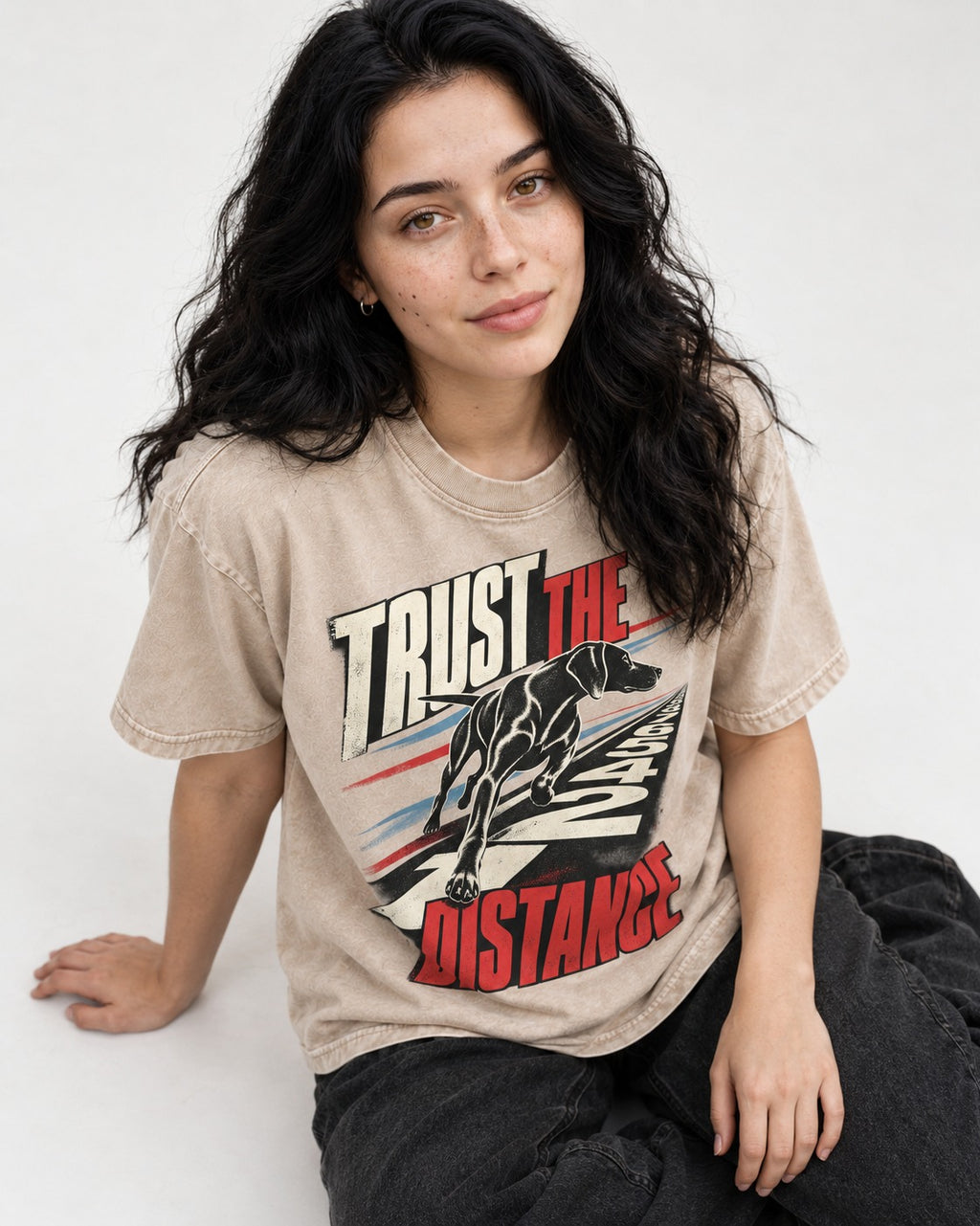 Trust the Distance German Shorthaired Pointer Graphic Washed Tee in Apricot, worn by a seated model