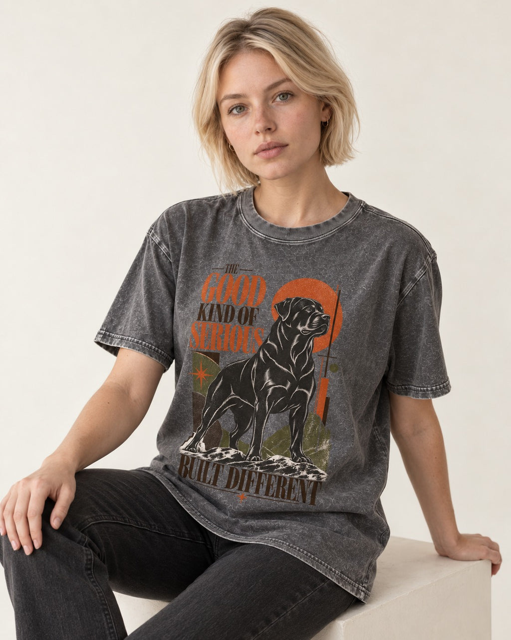 Rottweiler Built Different Washed Tee in Gray, worn by a seated model