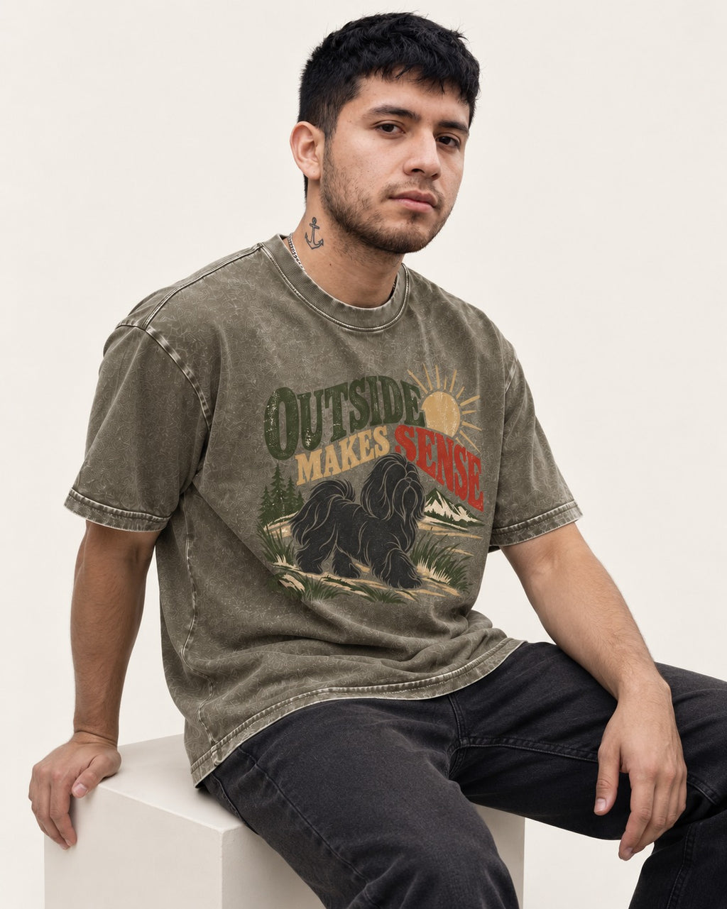Shih Tzu Outside Makes Sense Mountain Trail Graphic Washed Tee in Army Green, worn by a seated model