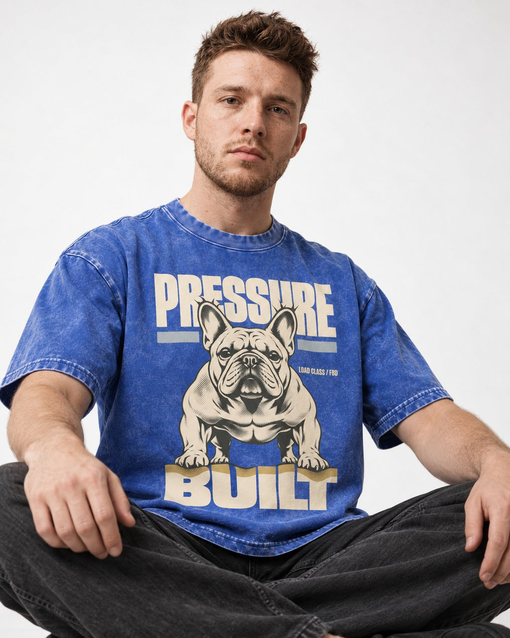 Frenchie Pressure Built Load Class Graphic Washed Tee in Royal Blue, worn by a seated model