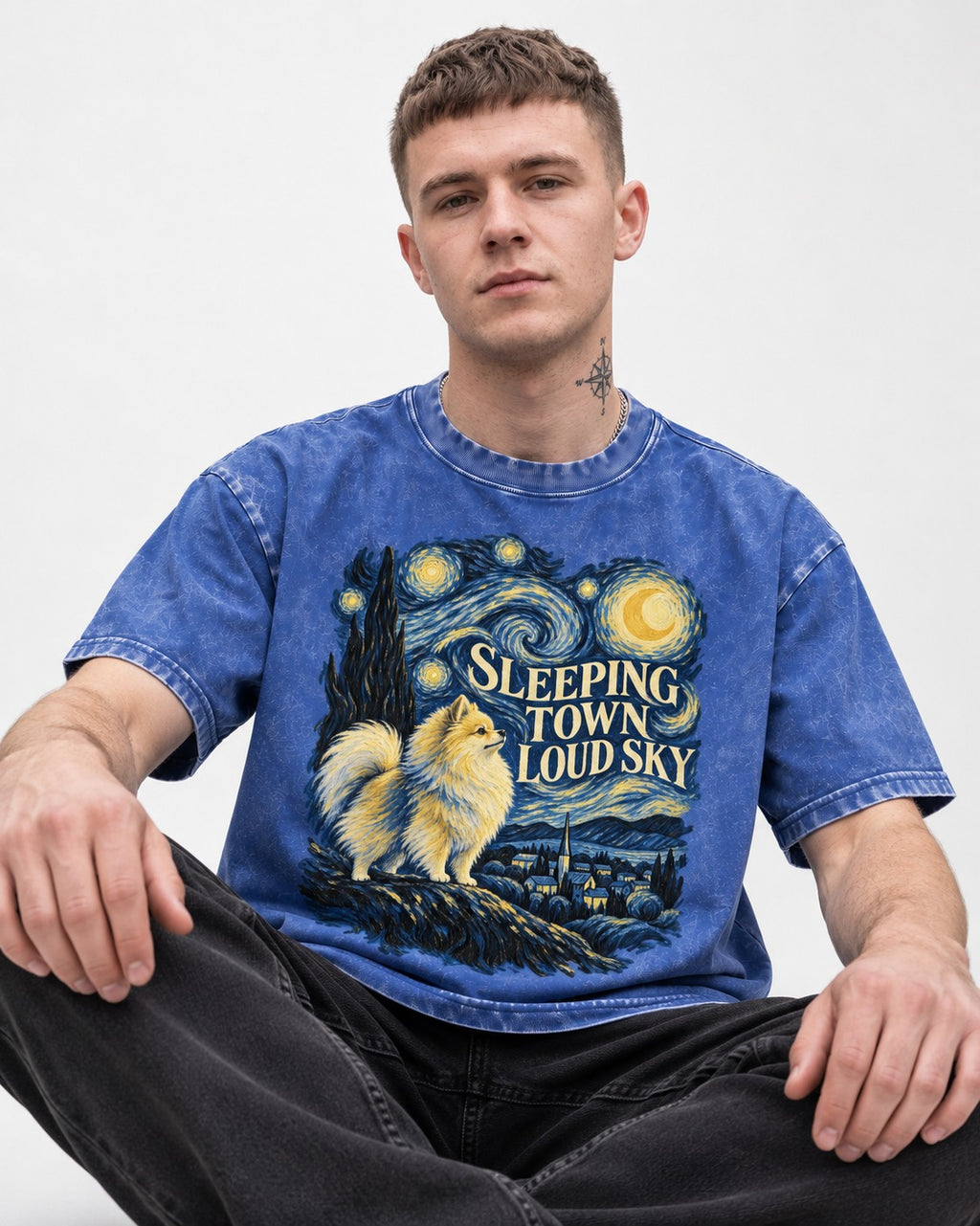Pomeranian Sleeping Town Loud Sky Starry Night Graphic Washed Tee in Royal Blue, worn by a seated model