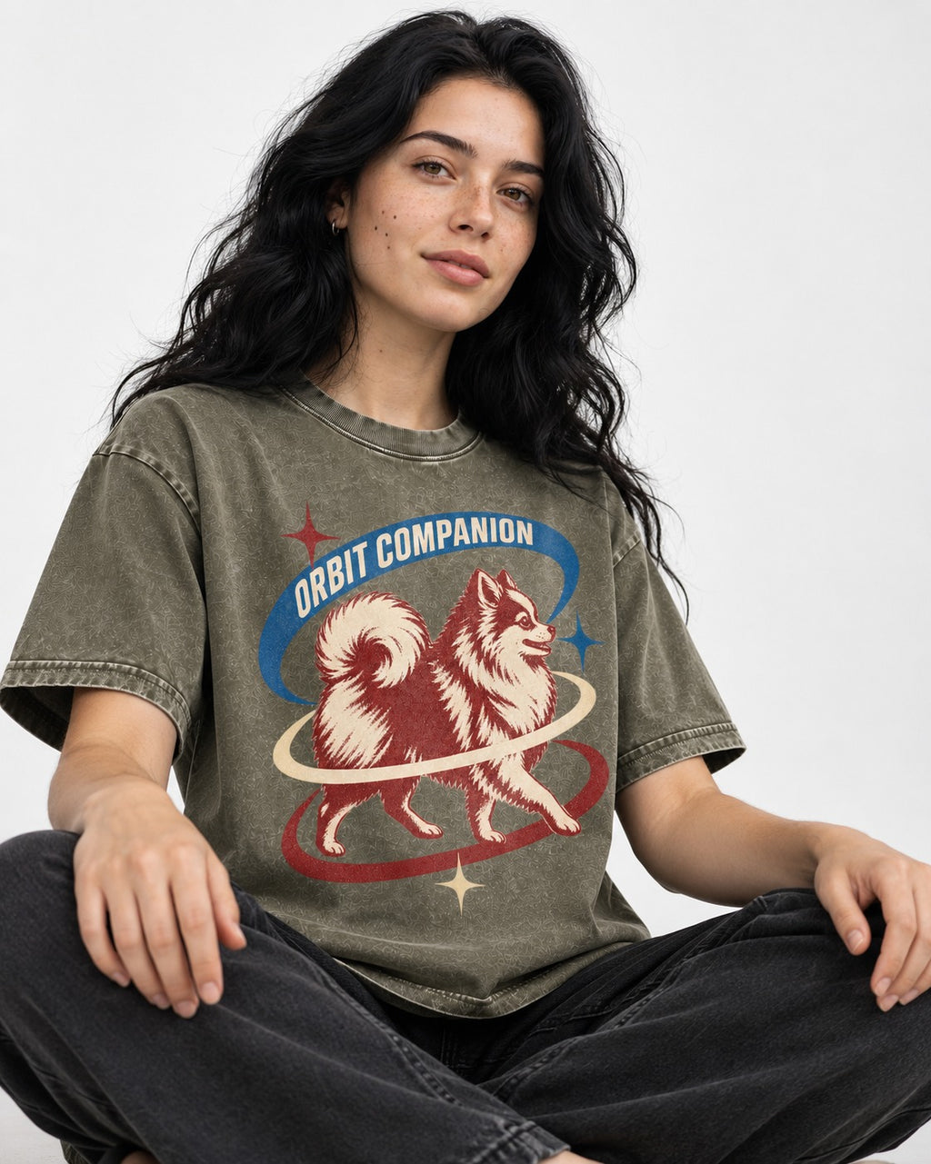Pomeranian Orbit Companion Retro Space Graphic Washed Tee in Army Green, worn by a seated model