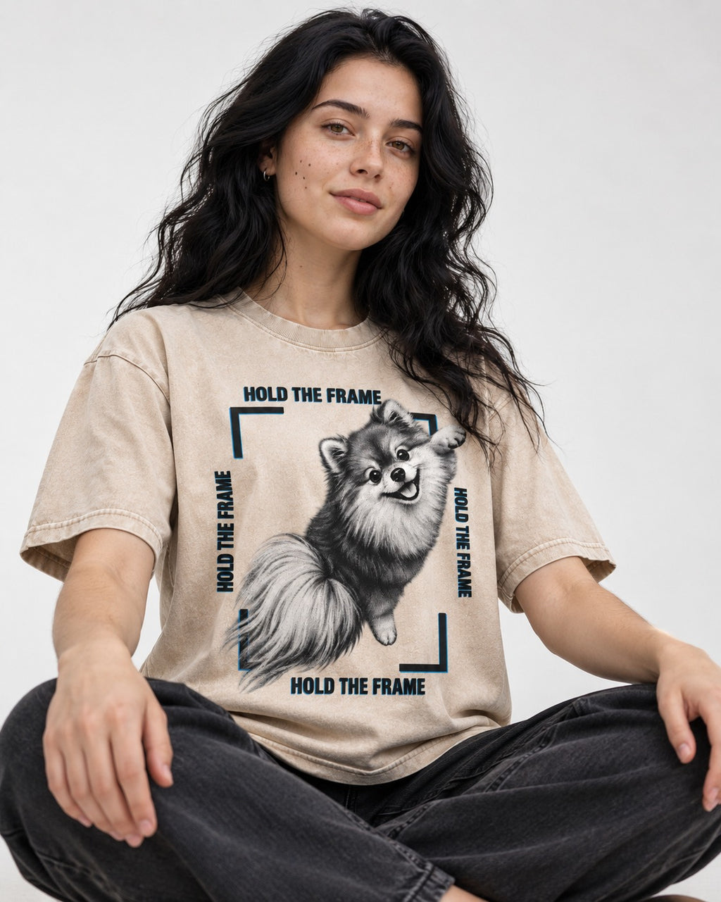 Hold the Frame Pomeranian Washed Tee in Apricot, worn by a seated model