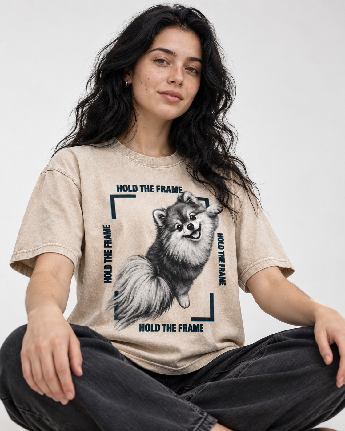 Hold the Frame Pomeranian Washed Tee in Apricot, worn by a seated model