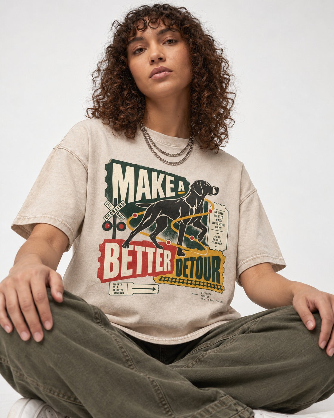 German Shorthaired Pointer Make a Better Detour Railroad Graphic Washed Tee in Apricot, worn by a seated model