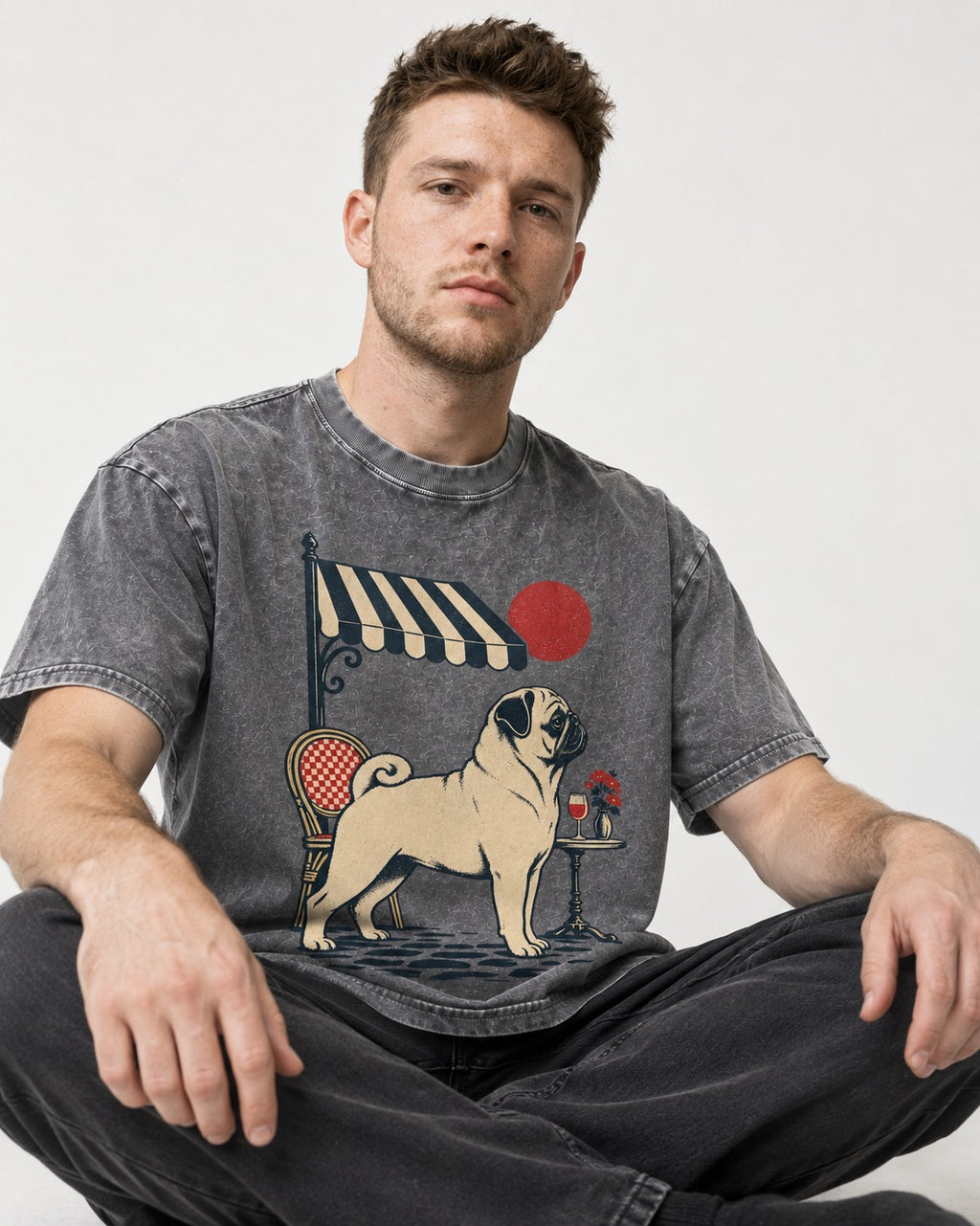 Pug Joie De Vivre Washed Tee in Gray, worn by a seated model