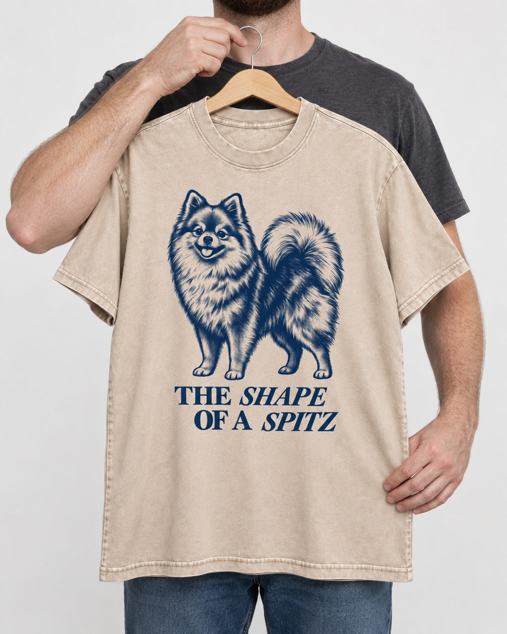 The Shape of a Pomeranian Washed Tee in Apricot, held up on a hanger
