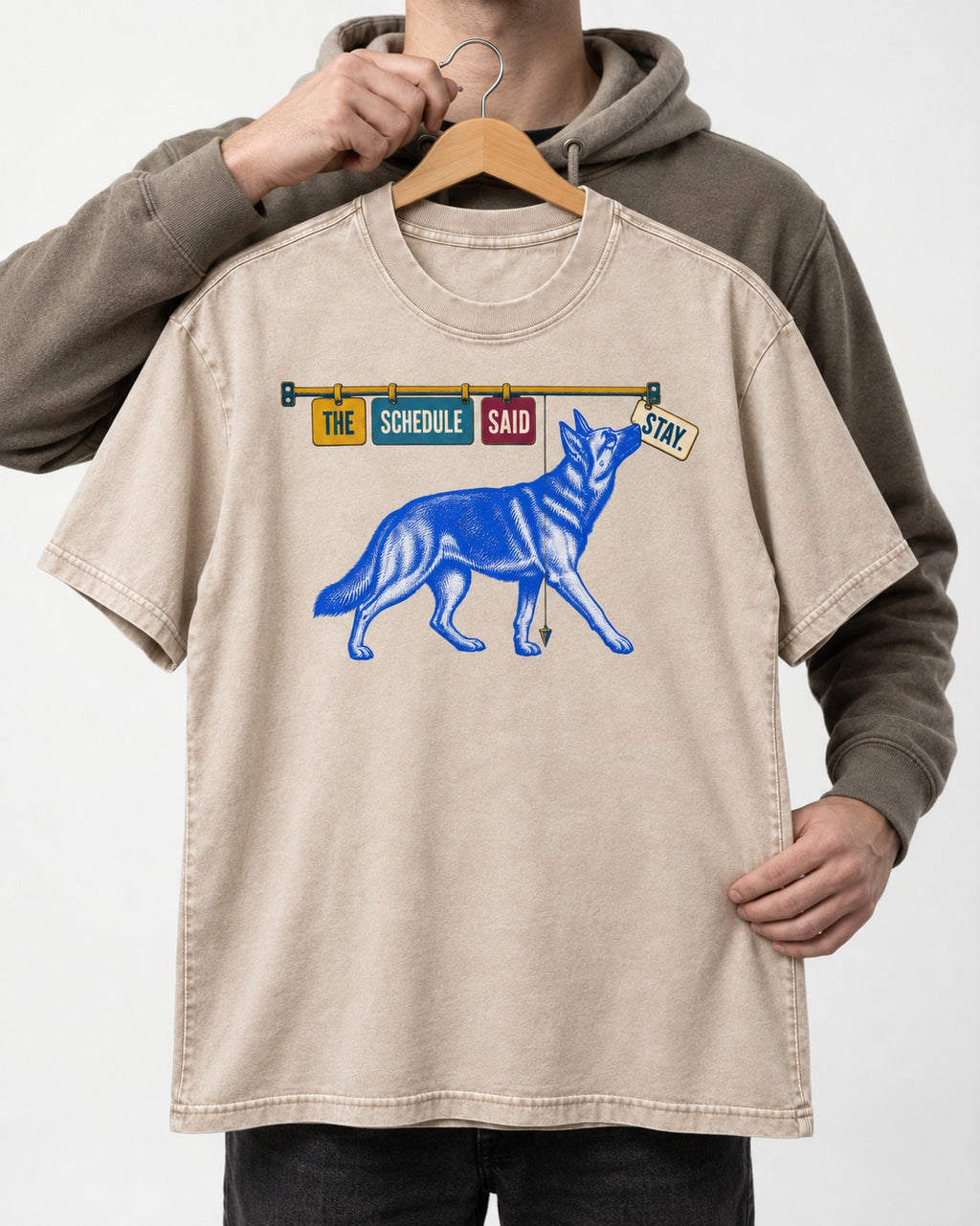 German Shepherd Dog The Schedule Said Stay Graphic Washed Tee in Apricot, held up on a hanger