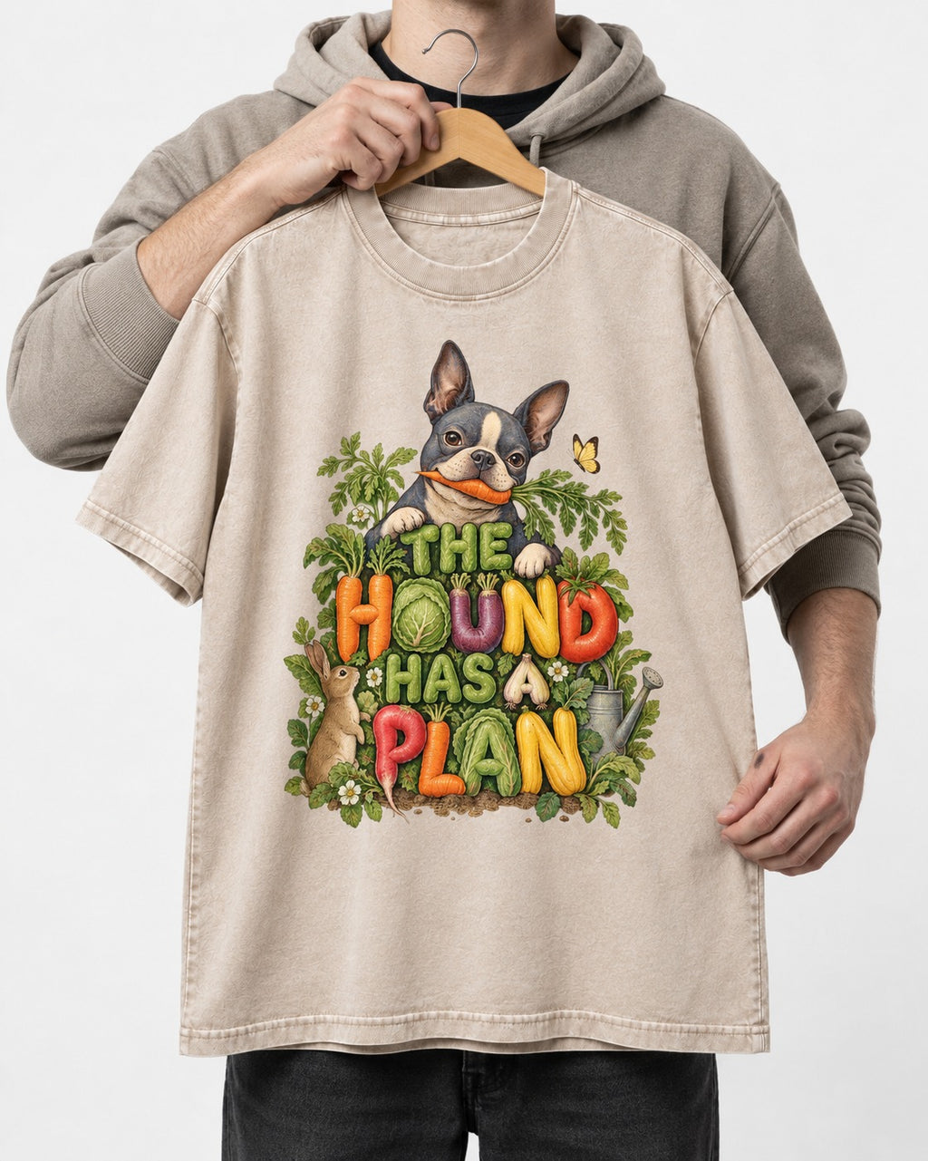 The Hound Has a Plan Boston Terrier Washed Tee in Apricot, held up on a hanger