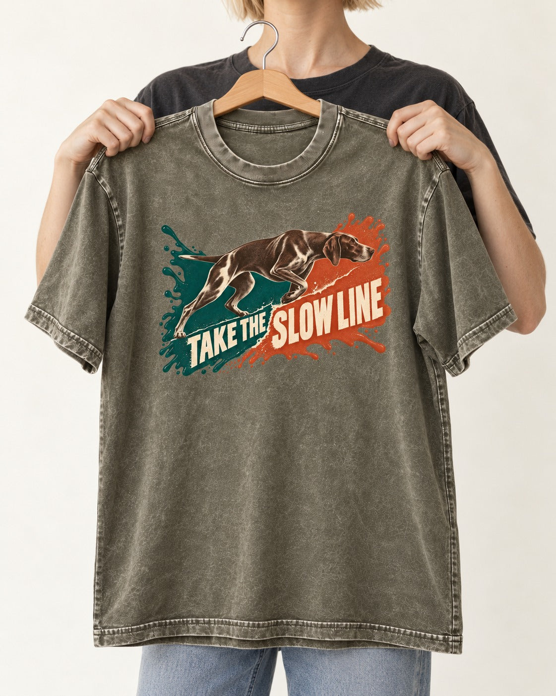German Shorthaired Pointer Take The Slow Line Paint Splash Graphic Washed Tee in Army Green, held up on a hanger