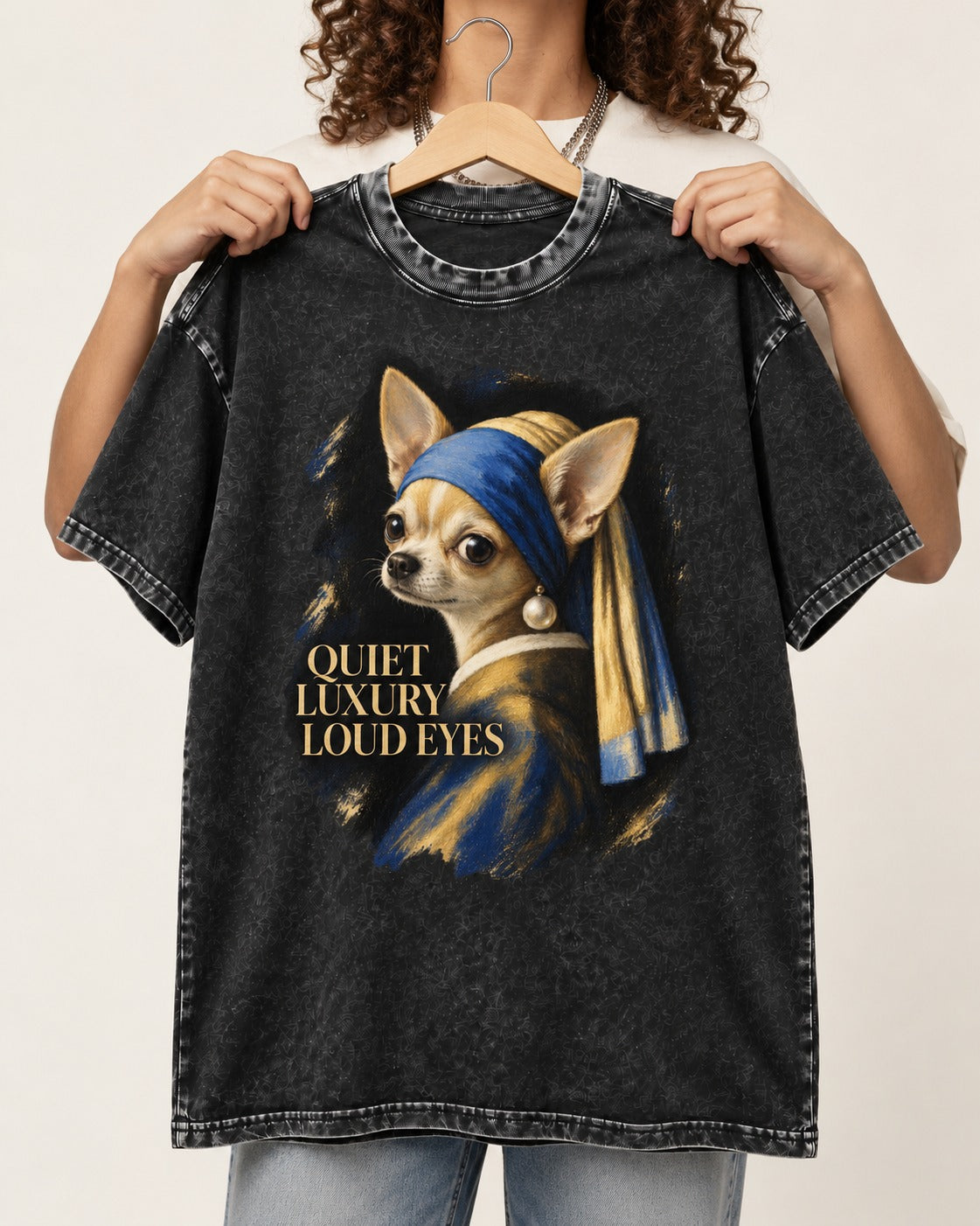 Chihuahua Quiet Luxury Loud Eyes Pearl Earring Portrait Washed Tee in Black, held up on a hanger