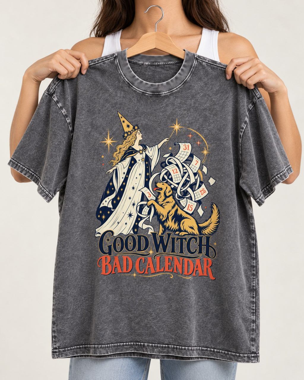 Good Witch Bad Calendar Golden Retriever Washed Tee in Gray, held up on a hanger