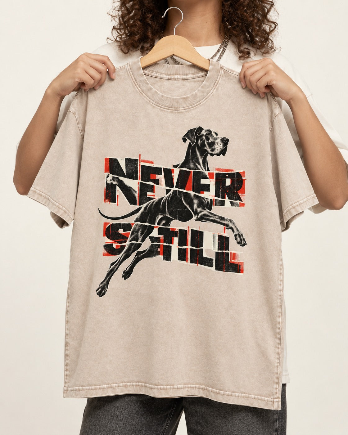 Great Dane Never Still Leaping Collage Graphic Washed Tee in Apricot, held up on a hanger