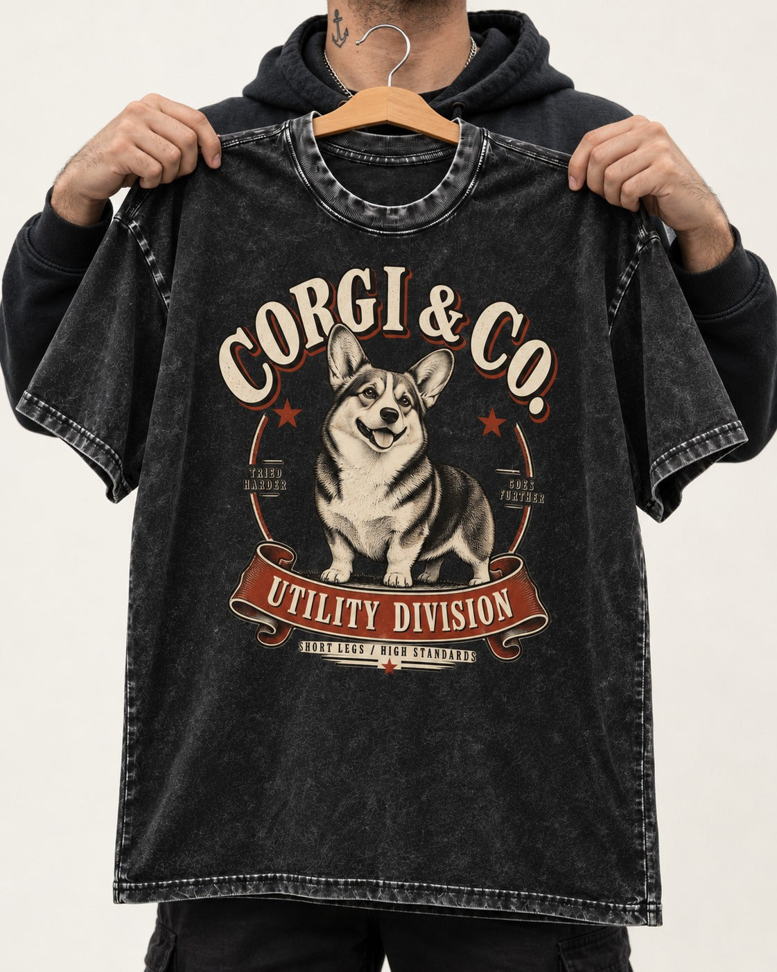 Corgi and Co Utility Division Emblem Washed Tee in Black, held up on a hanger