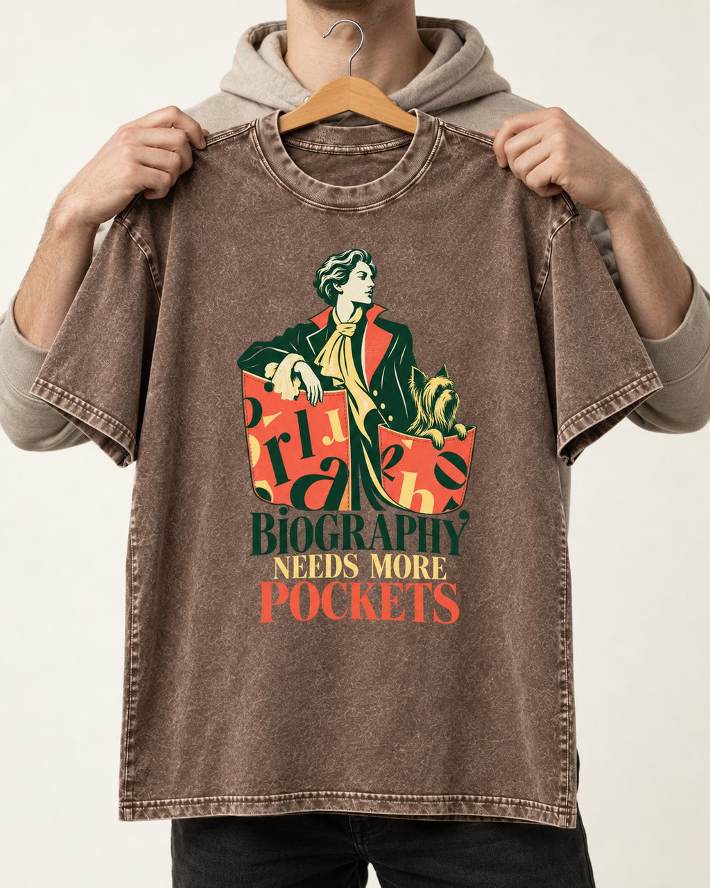 Yorkshire Terrier Biography Needs More Pockets Literary Portrait Graphic Washed Tee in Coffee, held up on a hanger