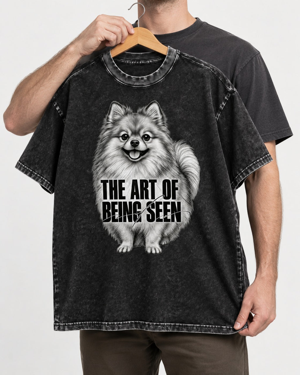 Pomeranian The Art of Being Seen Portrait Graphic Washed Tee in Black, held up on a hanger
