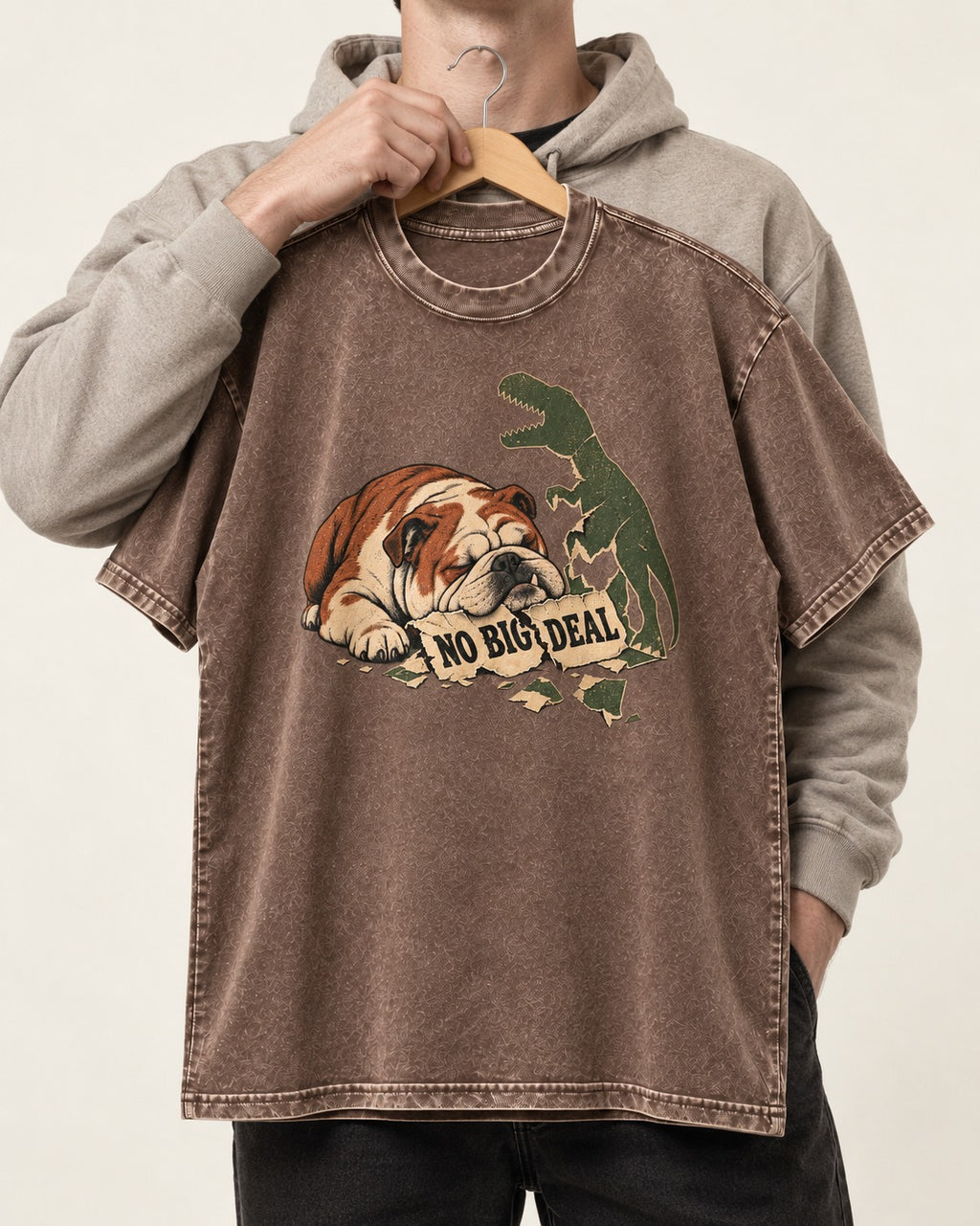 English Bulldog No Big Deal Dinosaur Graphic Washed Tee in Coffee, held up on a hanger