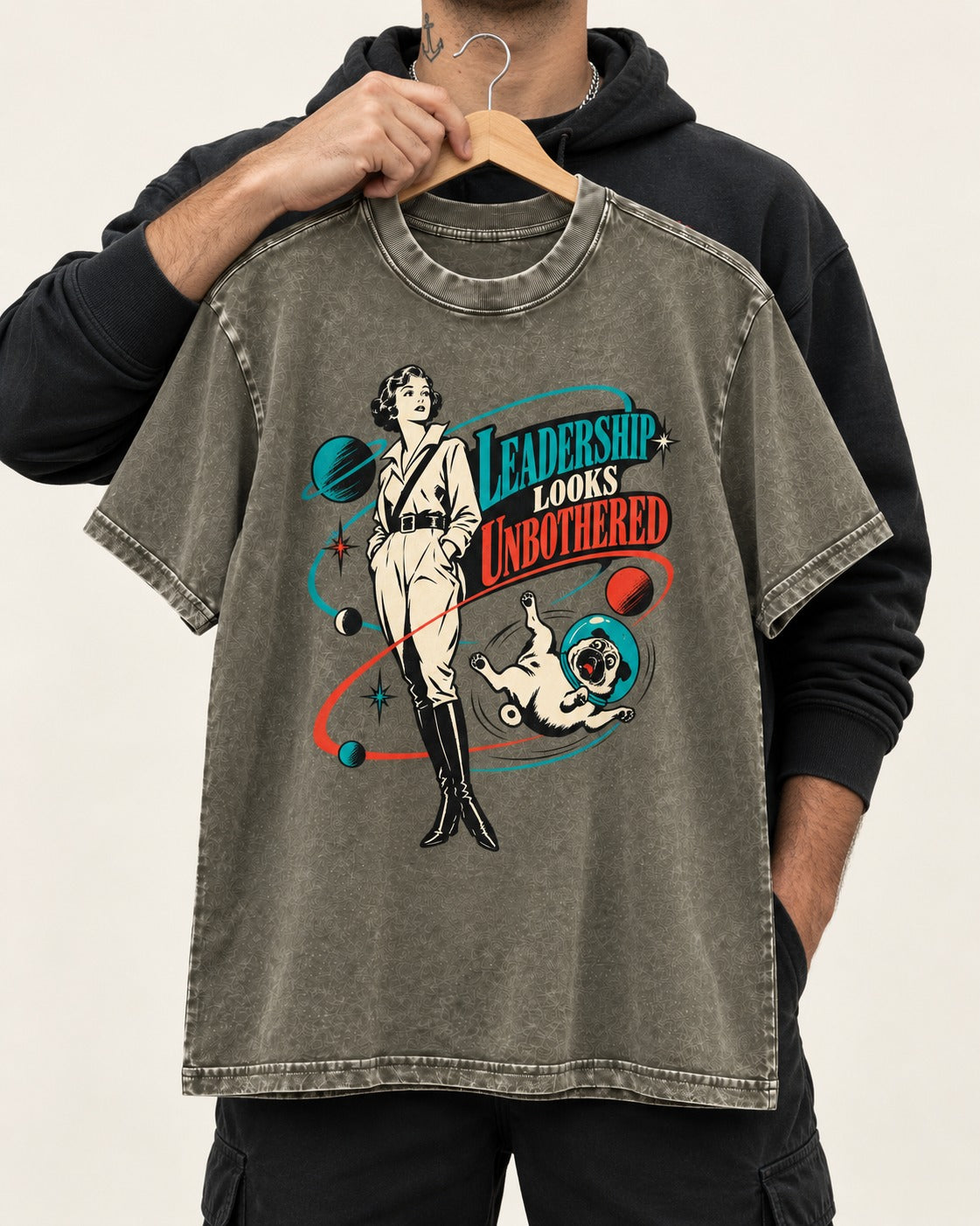 Pug Leadership Looks Unbothered Space Graphic Washed Tee in Army Green, held up on a hanger