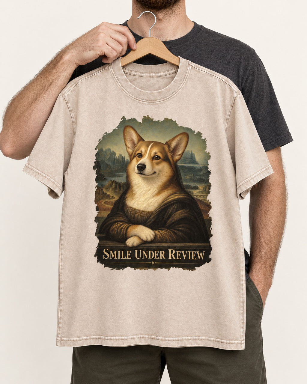 Corgi Smile Under Review Mona Lisa Portrait Washed Tee in Apricot, held up on a hanger