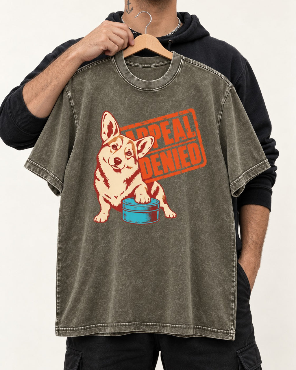 Corgi Appeal Denied Treat Tin Washed Tee in Army Green, held up on a hanger