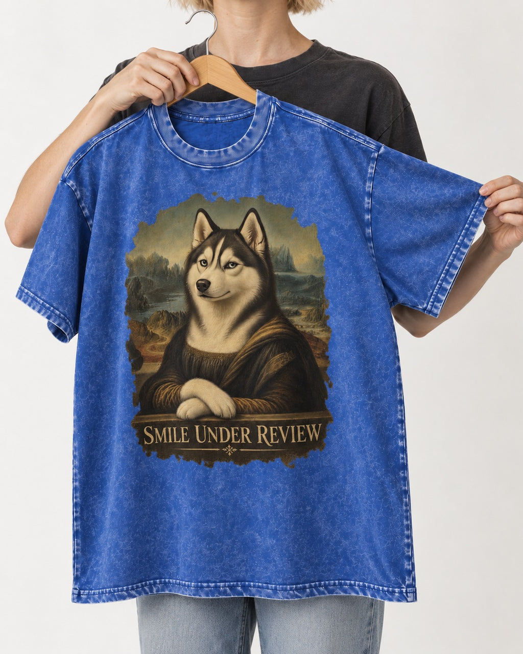 Husky Smile Under Review Renaissance Portrait Graphic Washed Tee in Royal Blue, held up on a hanger