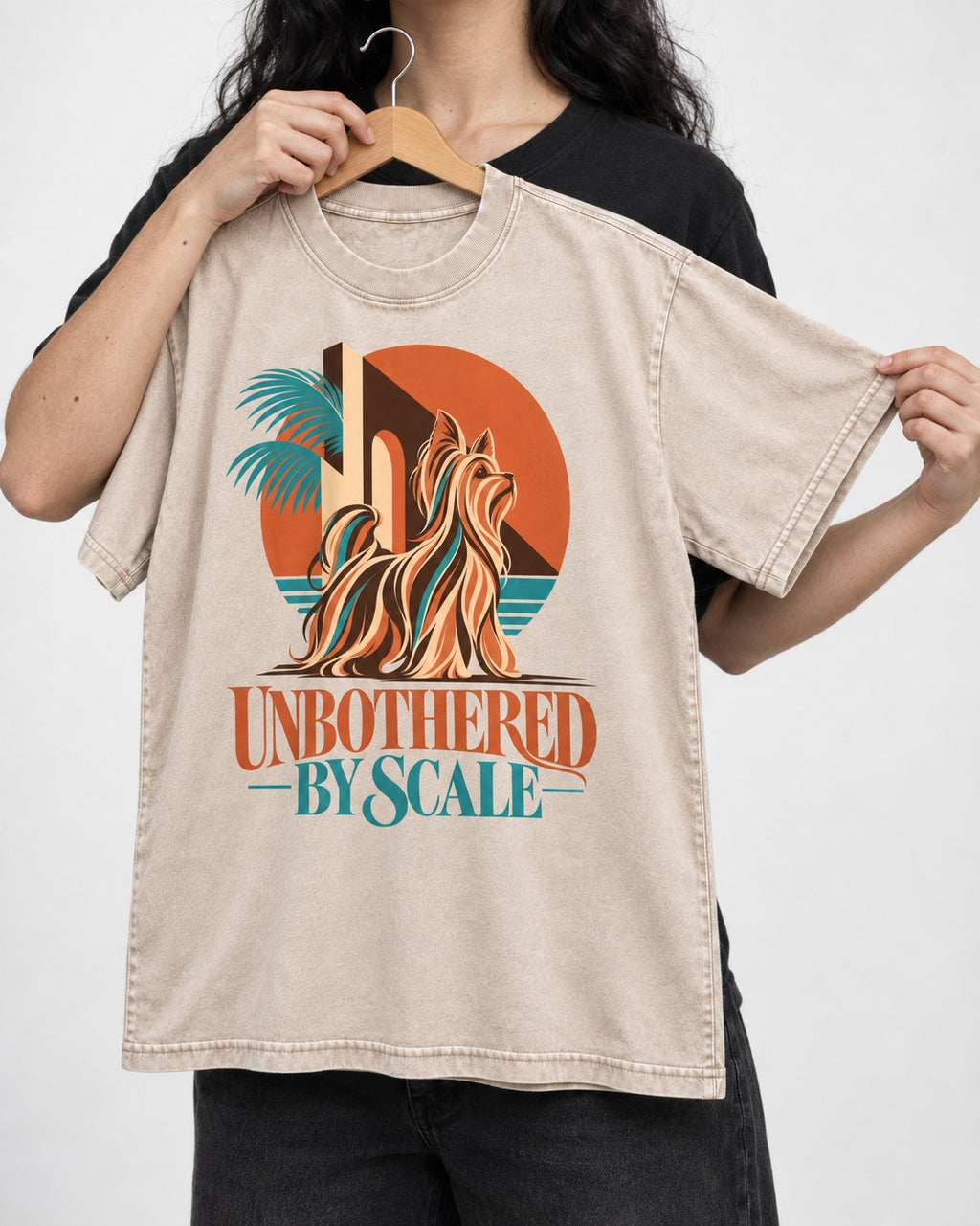 Yorkshire Terrier Unbothered by Scale Tropical Architecture Graphic Washed Tee in Apricot, held up on a hanger