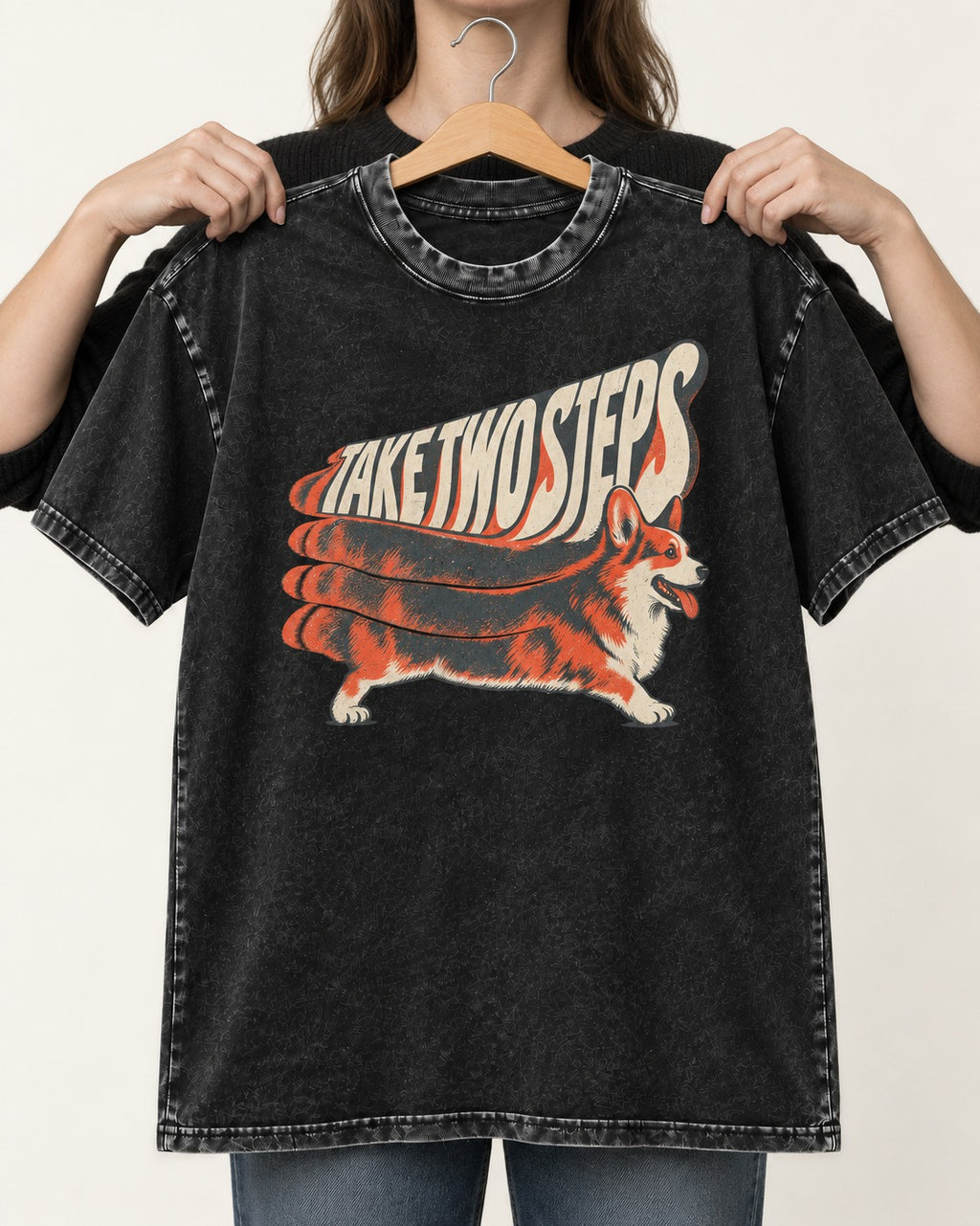 Corgi Take Two Steps Motion Trail Graphic Washed Tee in Black, held up on a hanger