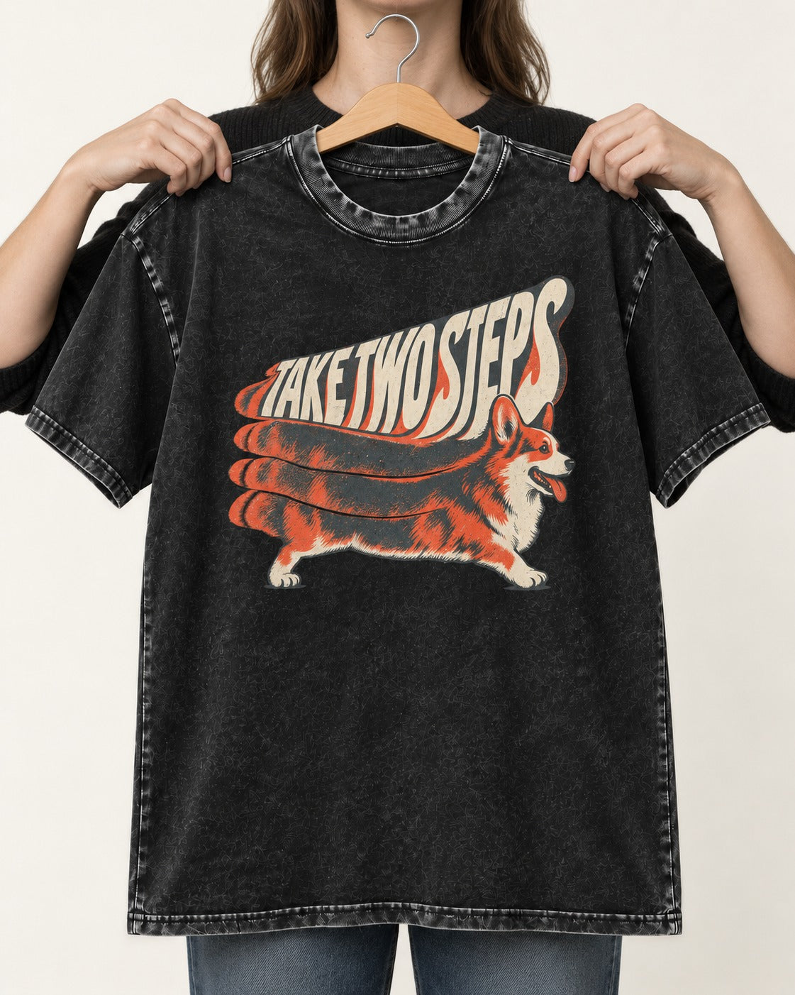 Corgi Take Two Steps Motion Trail Graphic Washed Tee in Black, held up on a hanger