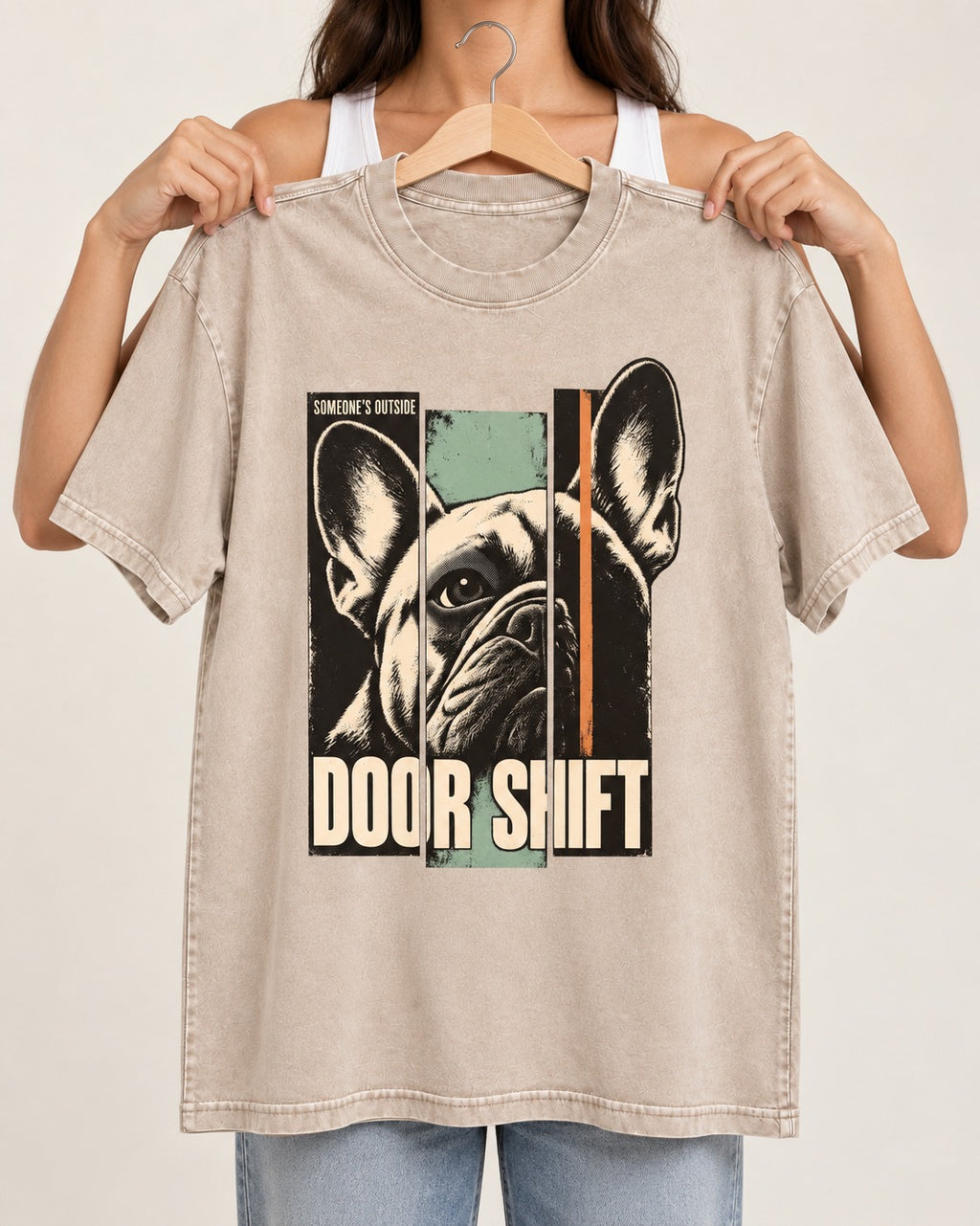 Frenchie Someone's Outside Door Shift Graphic Washed Tee in Apricot, held up on a hanger