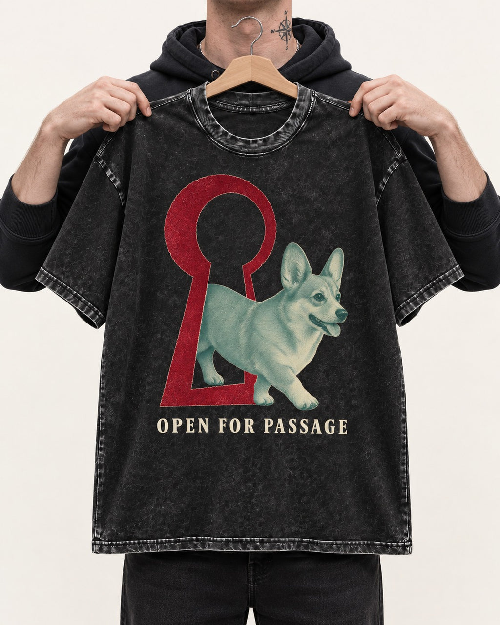 Corgi Open for Passage Keyhole Graphic Washed Tee in Black, held up on a hanger