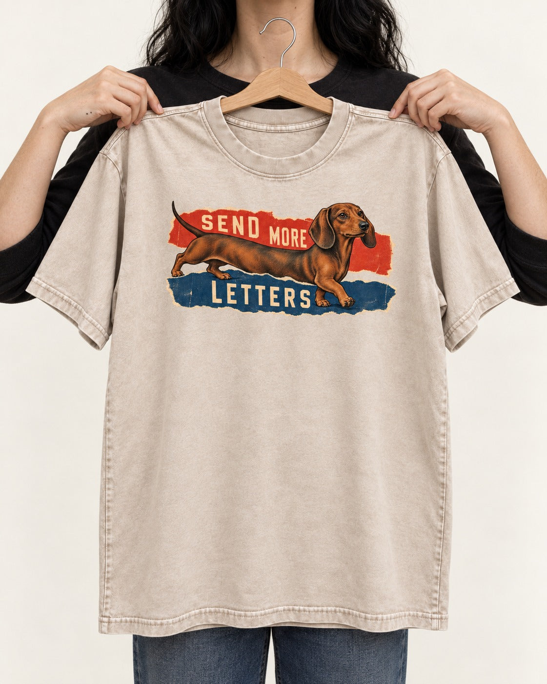 Dachshund Send More Letters Torn Paper Graphic Washed Tee in Apricot, held up on a hanger