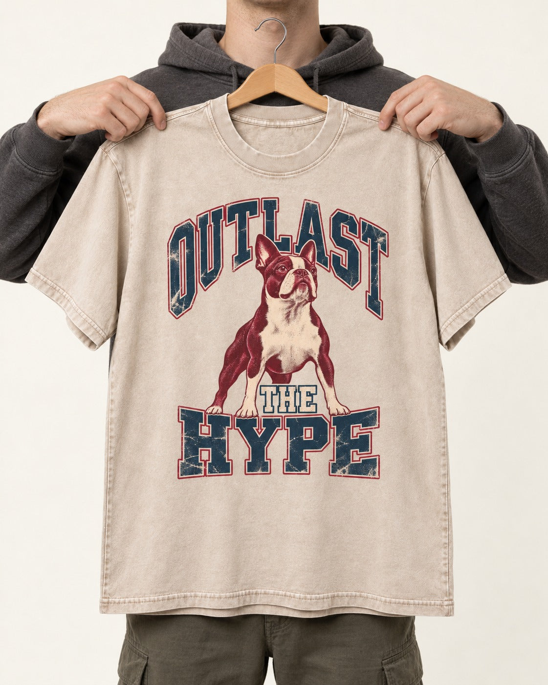 Boston Terrier Outlast The Hype Collegiate Graphic Washed Tee in Apricot, held up on a hanger