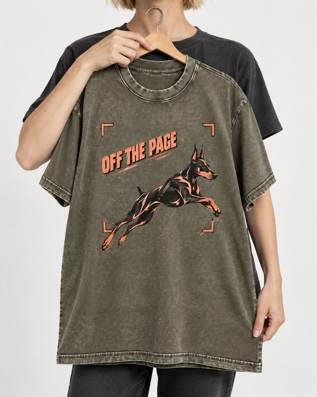 Doberman Off the Page Focus Frame Graphic Washed Tee in Army Green, held up on a hanger