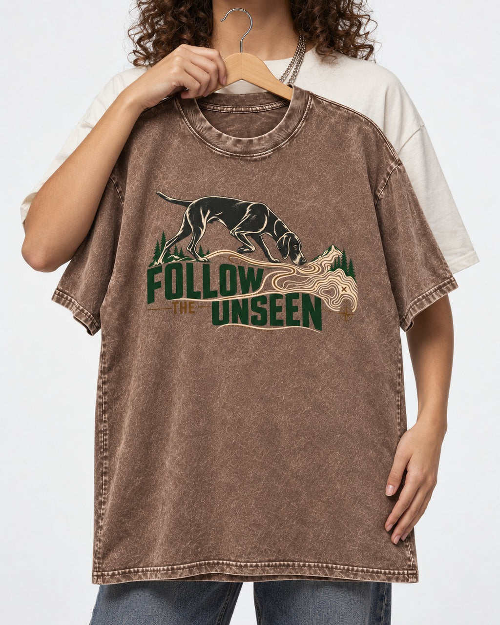 Follow the Unseen German Shorthaired Pointer Washed Tee in Coffee, held up on a hanger