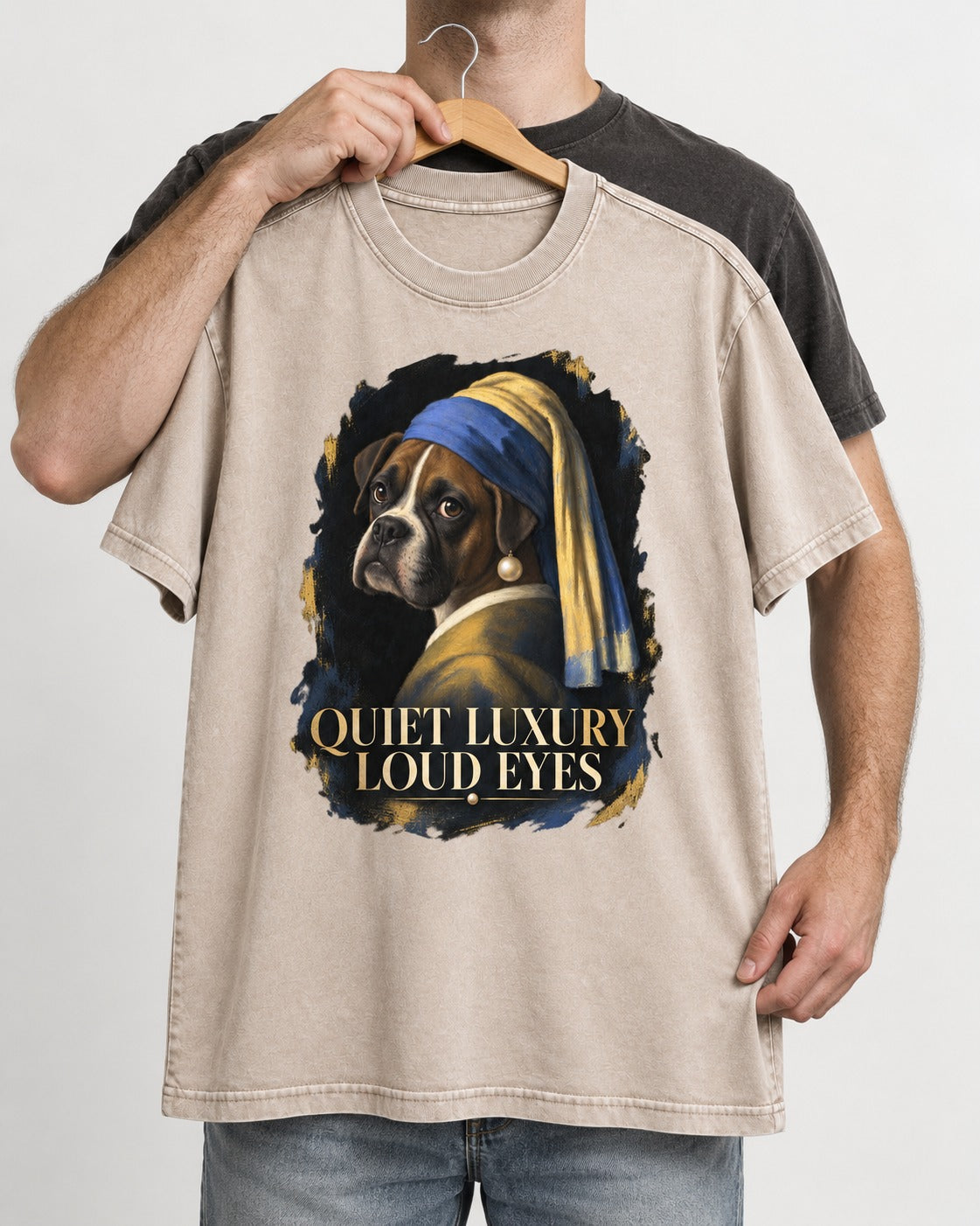 Quiet Luxury Loud Eyes Boxer Pearl Portrait Washed Tee in Apricot, held up on a hanger