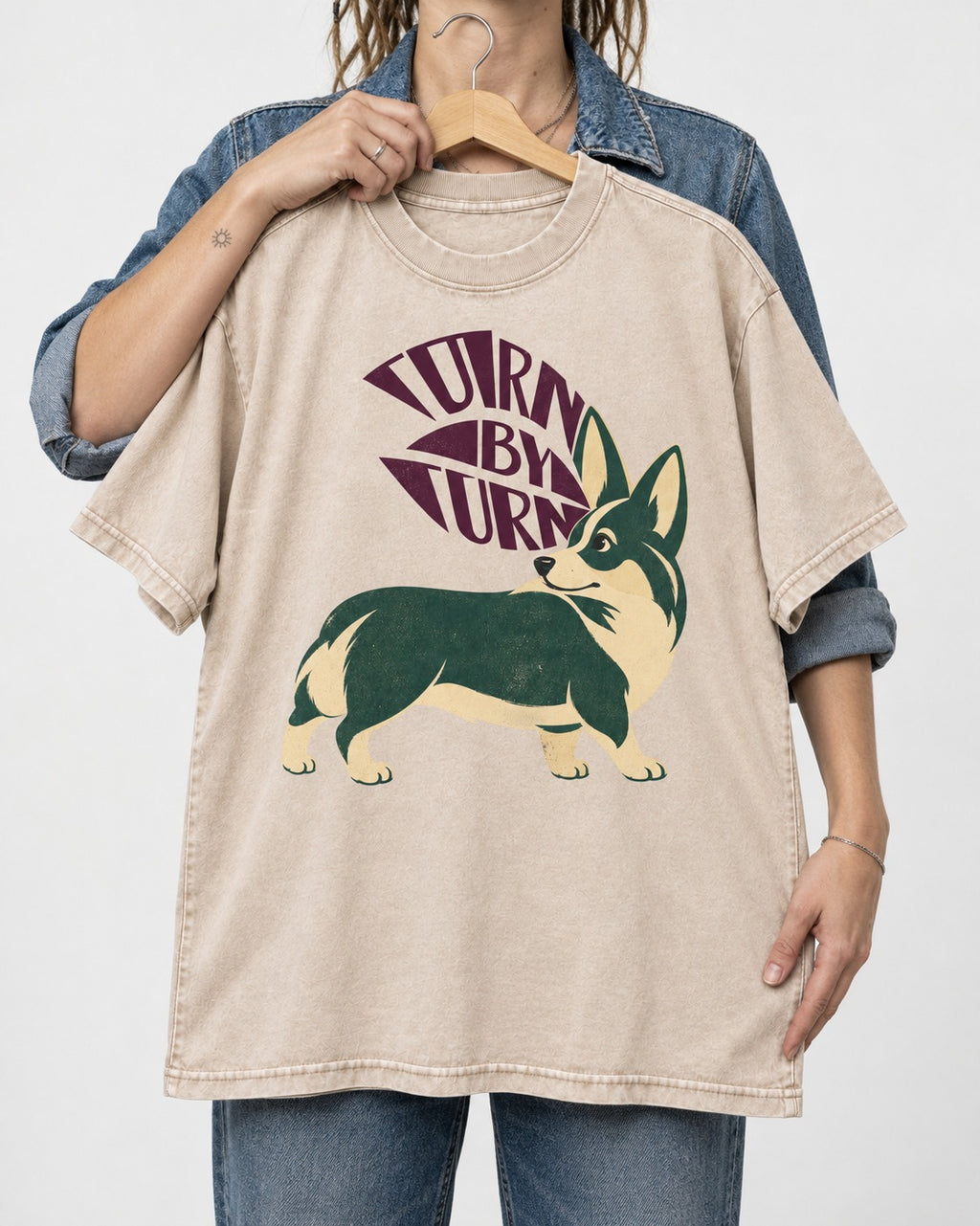 Turn by Turn Corgi Washed Tee in Apricot, held up on a hanger
