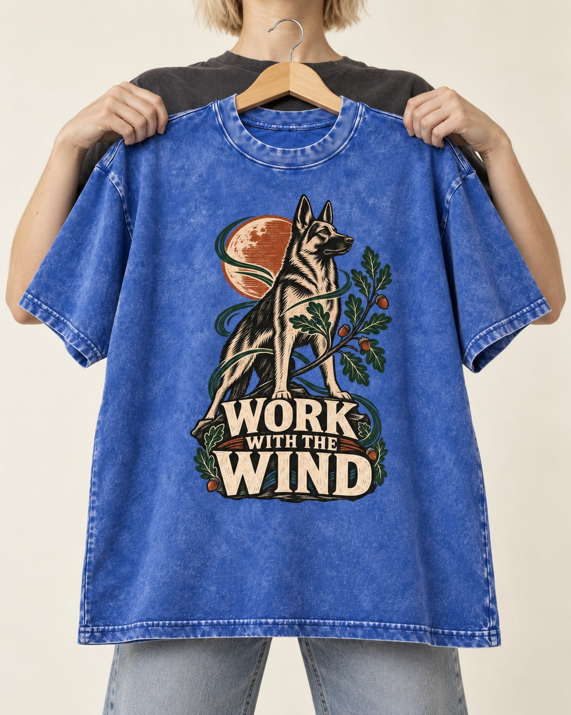 Work With The Wind Botanical Woodcut German Shepherd Dog Graphic Washed Tee in Royal Blue, held up on a hanger