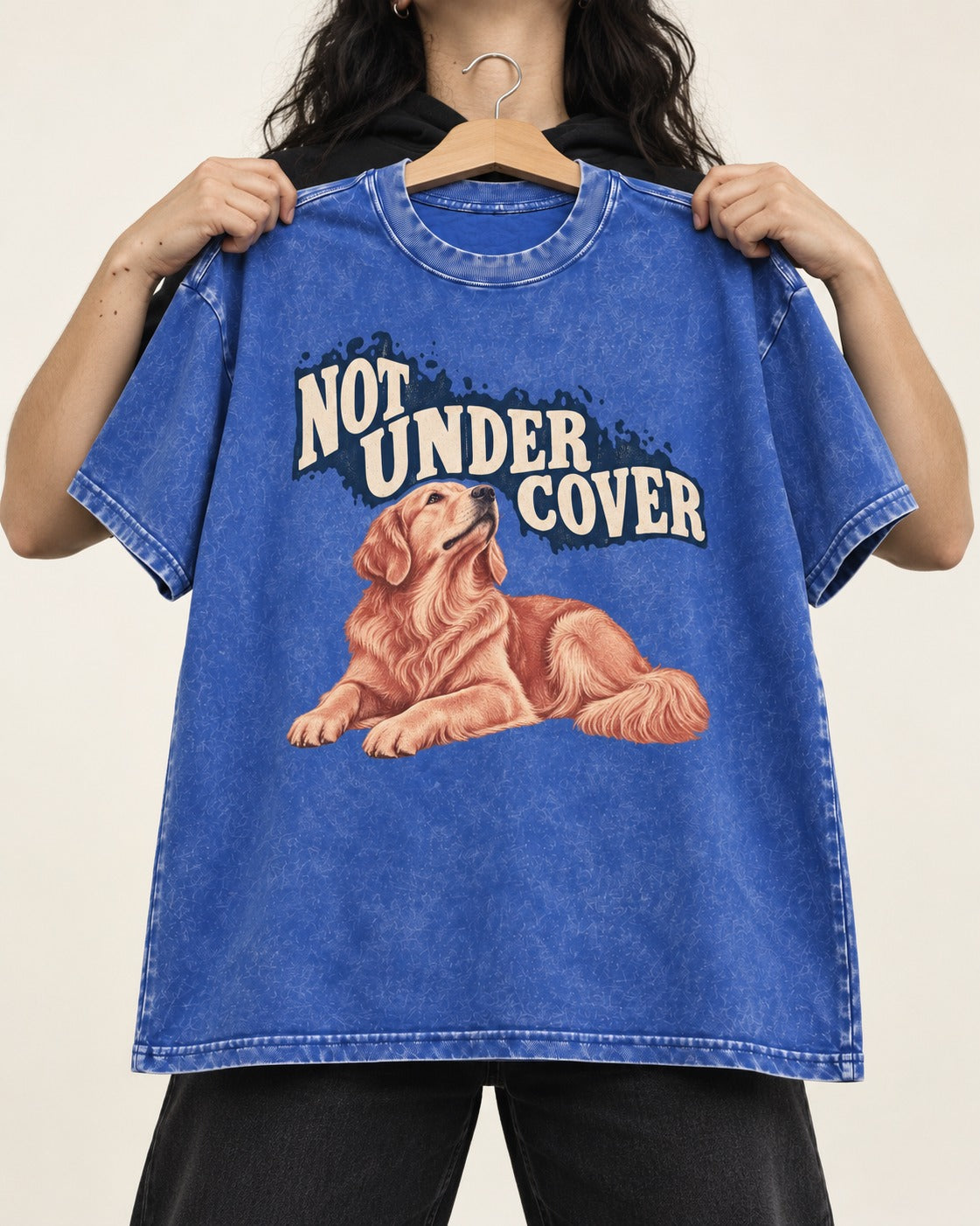 Not Under Cover Reclining Golden Retriever Graphic Washed Tee in Royal Blue, held up on a hanger