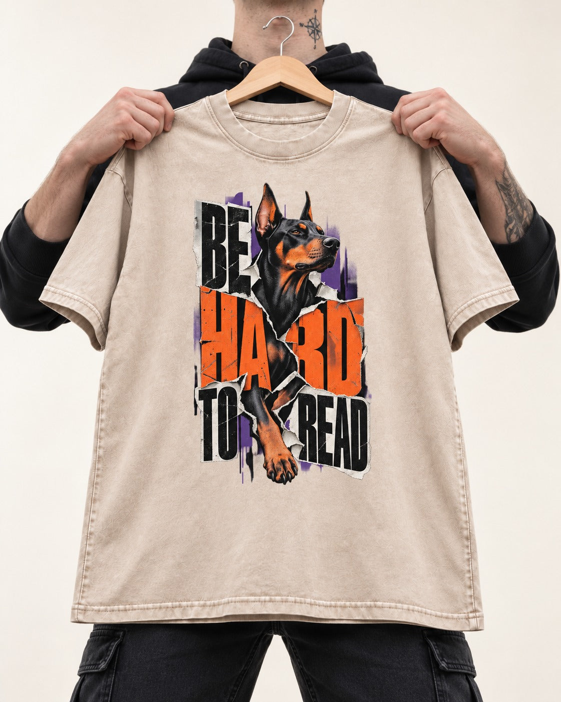 Doberman Be Hard to Read Torn Poster Graphic Washed Tee in Apricot, held up on a hanger