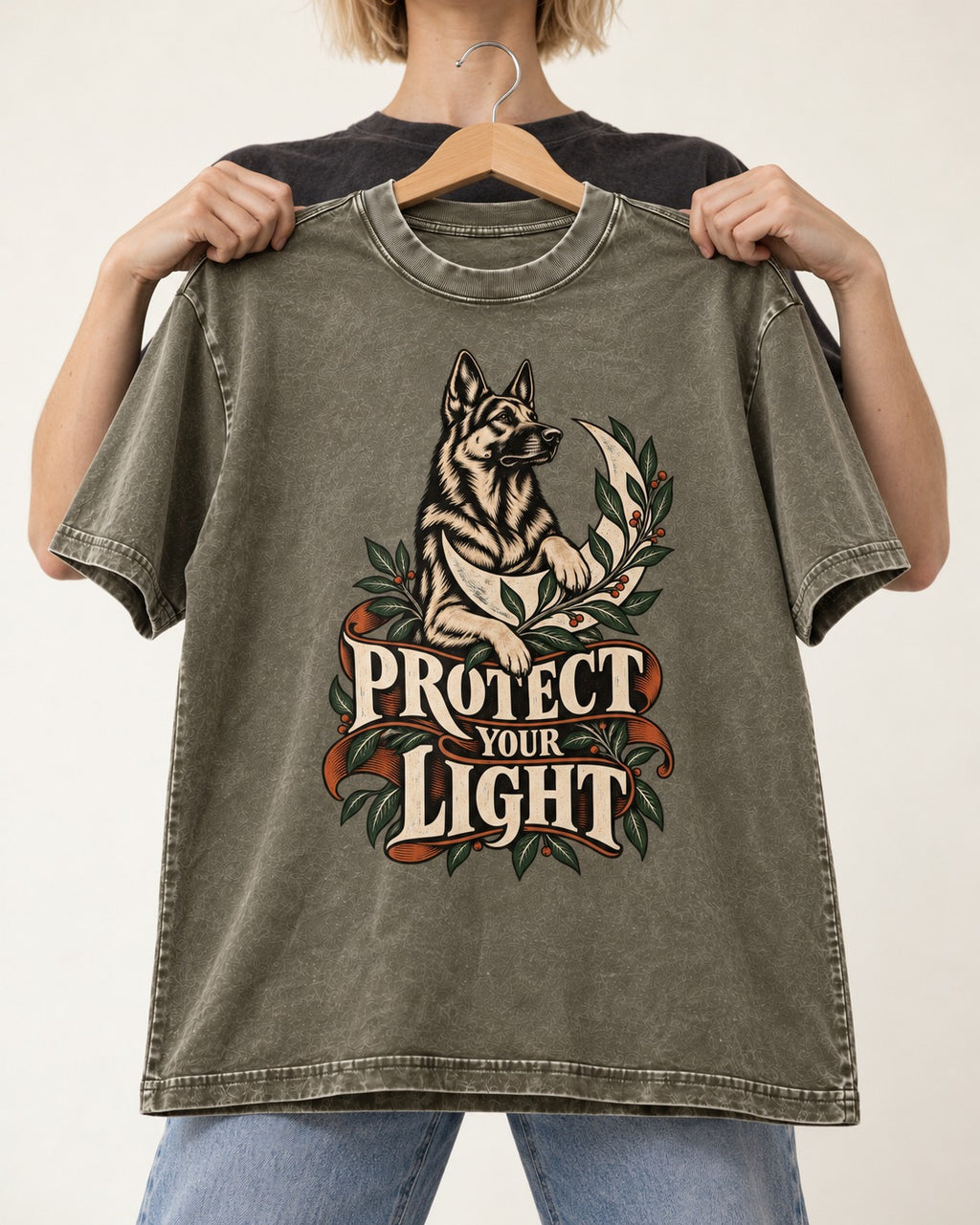 Protect Your Light Moon Botanical German Shepherd Dog Graphic Washed Tee in Army Green, held up on a hanger