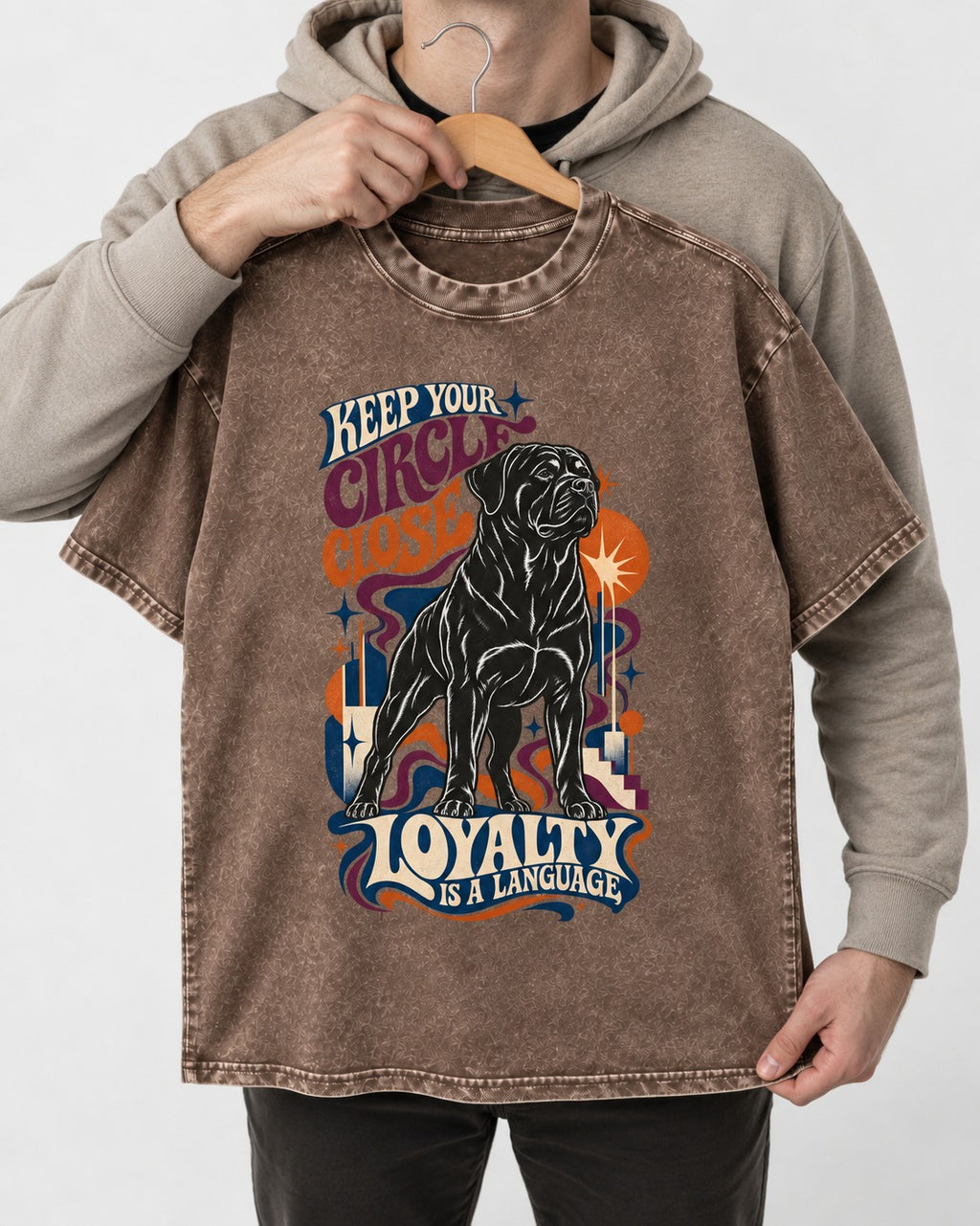 Keep Your Rottweiler Circle Close Washed Tee in Coffee, held up on a hanger